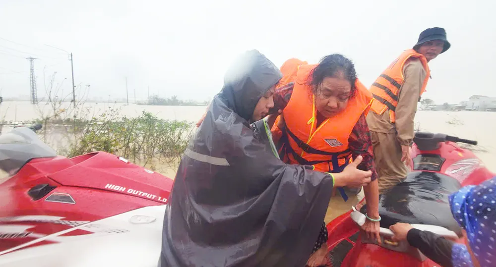 Hỗ trợ cụ bà thoát khỏi vùng ngập lụt nguy hiểm ở khu phố 3, phường Quy Nhơn Đông