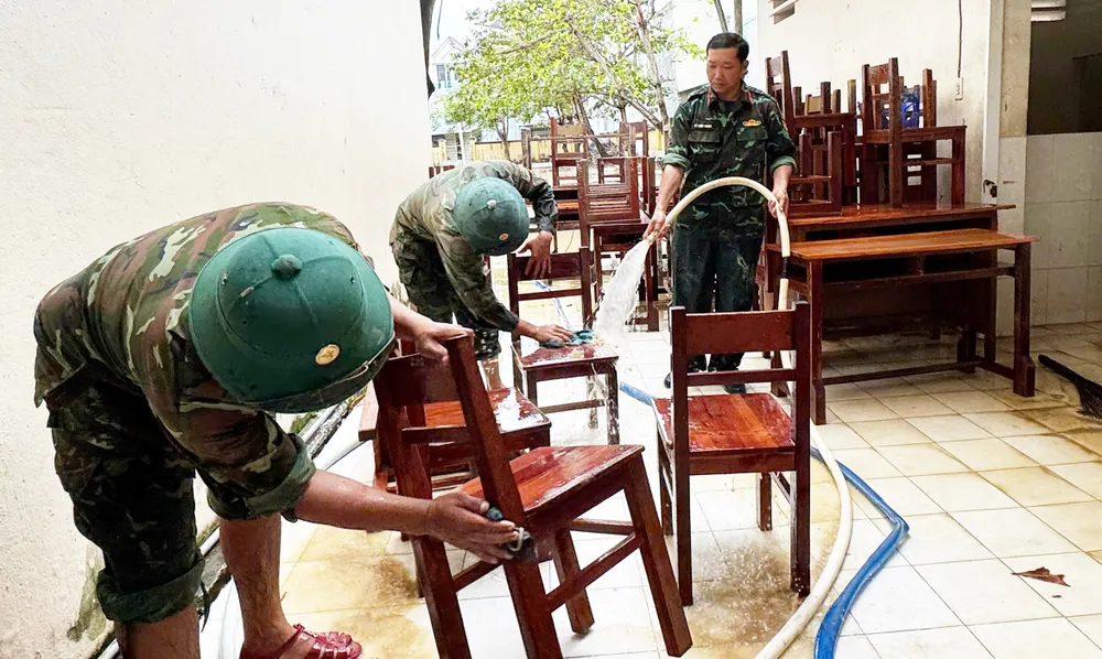 3- lực lượng CBCS giúp trường THCS chà rửa bàn ghế. Ảnh N.H.jpg