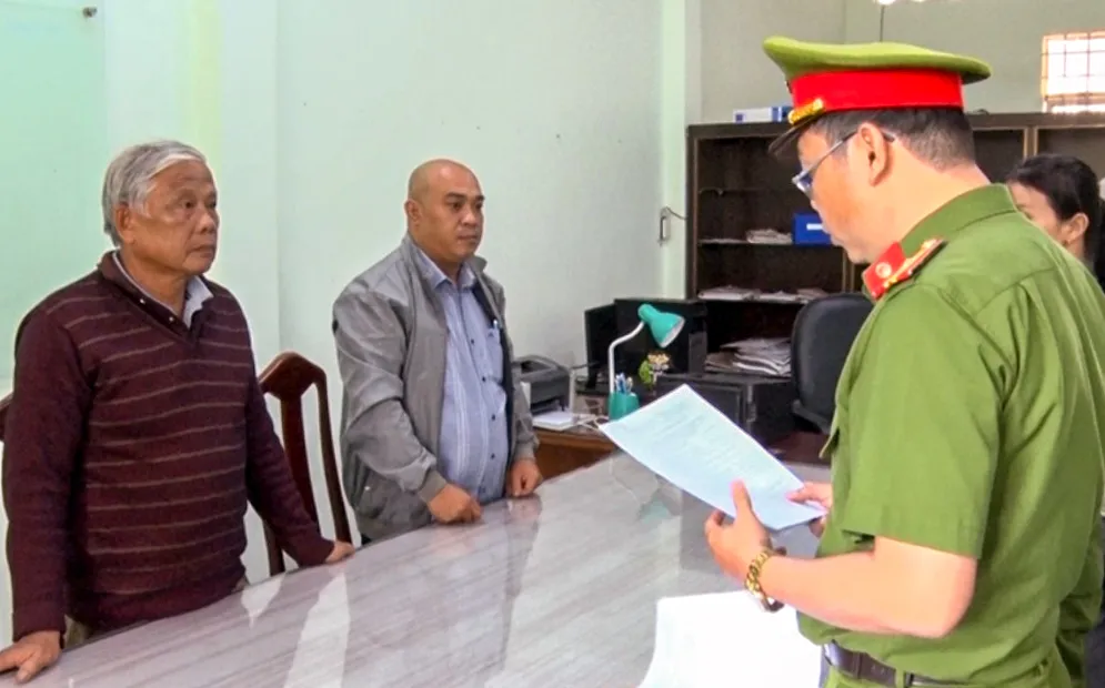 Cảnh sát đọc lệnh bắt 2 bị can Nguyễn Hữu Trường và Nguyễn Văn Phiêu. Ảnh: NGUYỄN VĂN