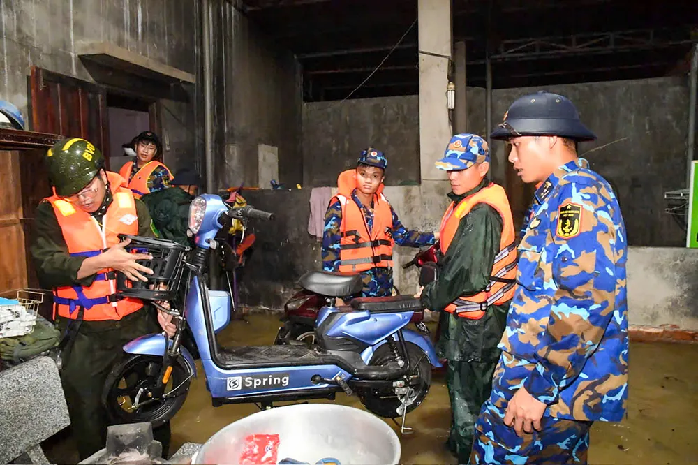 Cán bộ, chiến sĩ hỗ trợ người dân di dời tài sản.jpg