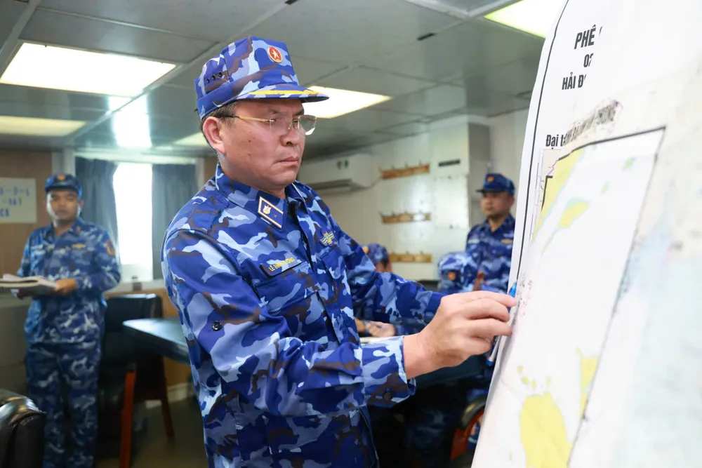 Thiếu tướng Lê Đình Cường kiểm tra kế hoạch phòng chống bão số 13 và tìm kiếm cứu nạn của Hải đoàn 32 trên hải đồ..jpg