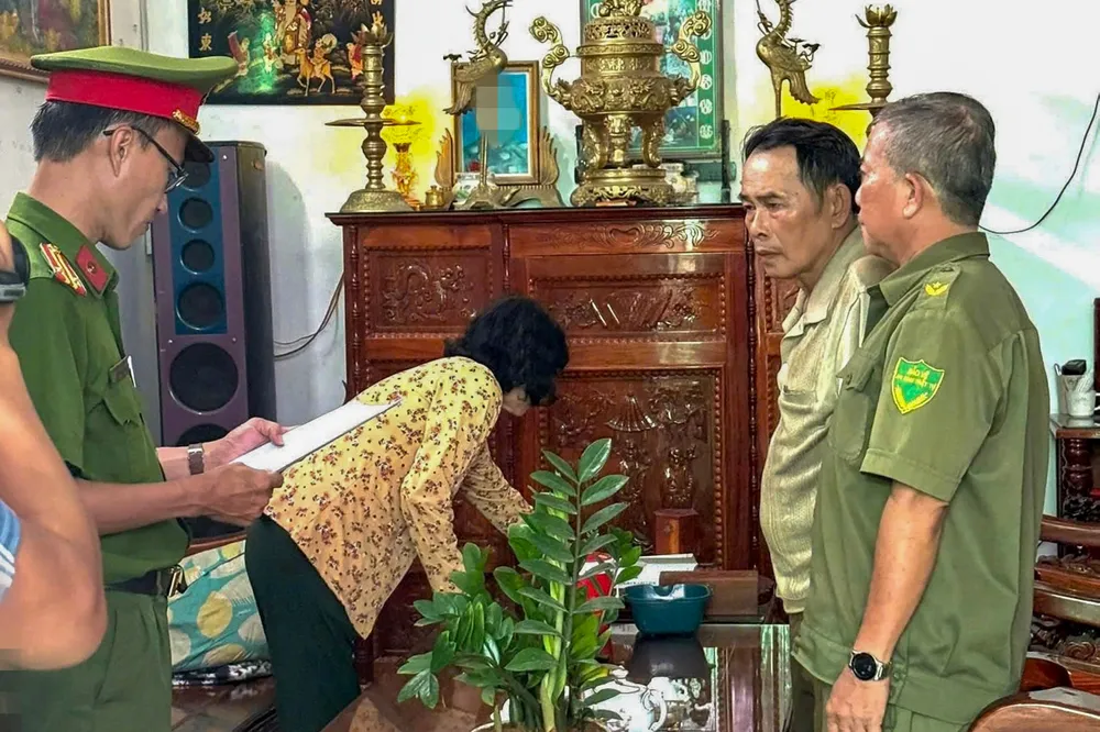 Công an đọc quyết định khởi tố bị can, lệnh bắt tạm giam đối với ông Lê Văn Hoàng. Ảnh: CTV