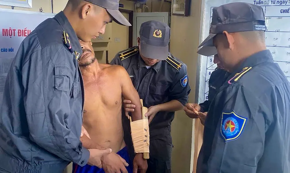 2 Cán bộ, nhân viên tàu KN-407 cố định vị trí tay bị gyax cho ngư dân Trần Văn Đèo.jpg