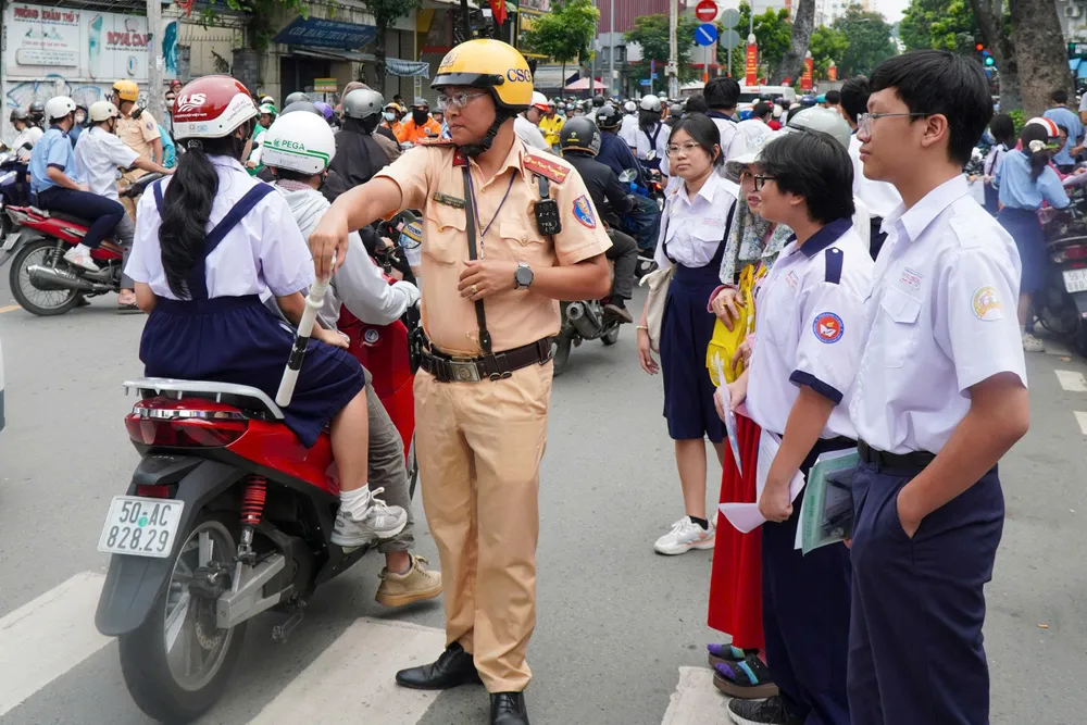 Lực lượng CSGT điều tiết giao thông trước cổng điểm thi trường THCS Lê Lợi (phường Xuân Hòa, TPHCM) (3).jpg