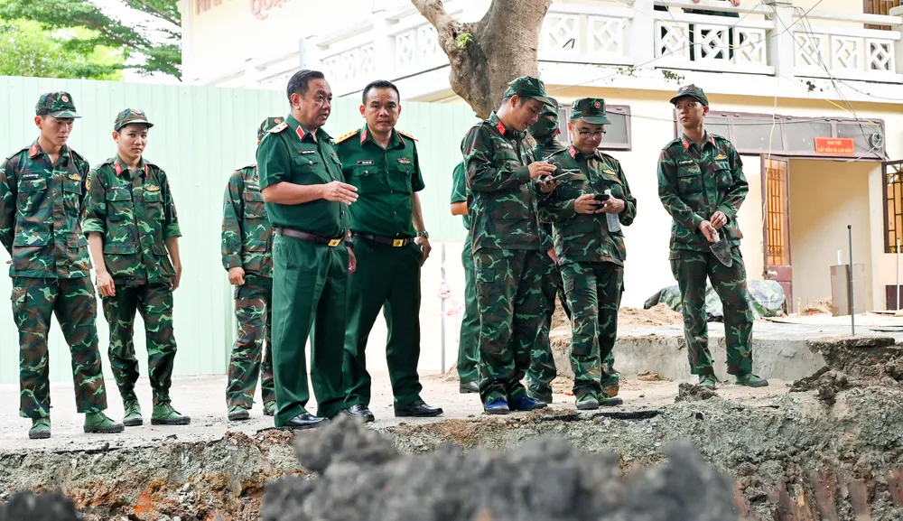 Thiếu tướng Nguyễn Thành Trung (hàng đầu, thứ 2 từ trái qua) chỉ đạo tại hiện trường mở rộng tìm kiếm, khai quật hài cốt liệt sĩ tại Công viên Lê Thị Riêng, ngày 9-7 (3).jpg