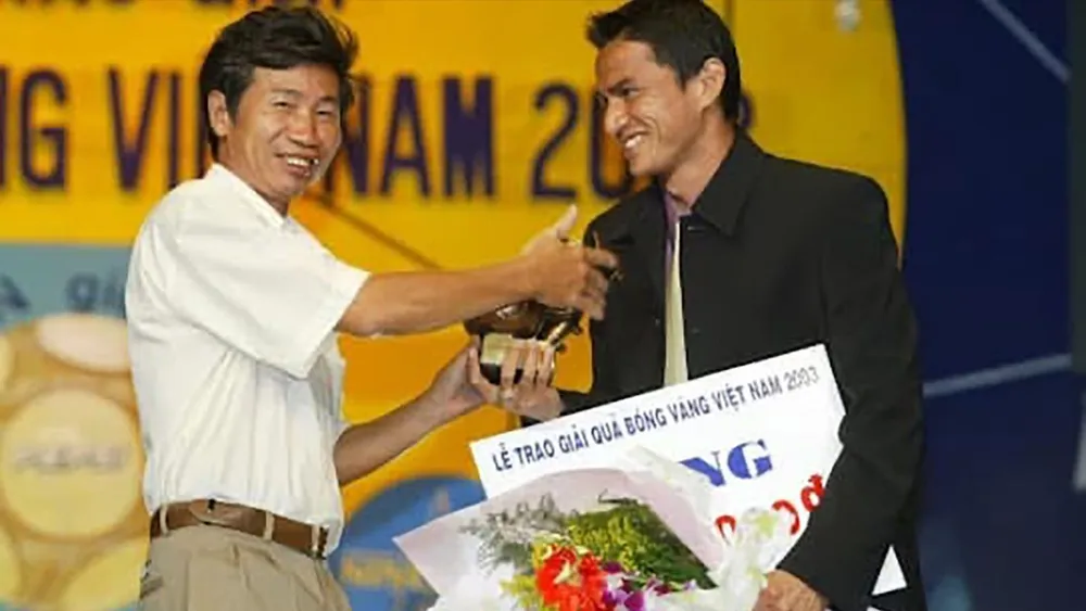 Phó Tổng Biên tập Báo SGGP Trần Văn Tuấn trao giải “Cầu thủ nước ngoài xuất sắc” năm 2003 cho tiền đạo Kiatisak, tối 3-3-2004. Ảnh: HOÀNG HÙNG
