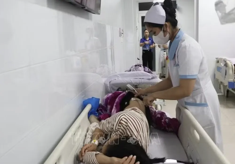 Bệnh nhân nghi ngộ độc thực phẩm được tiêm kháng sinh, truyền dịch tại bệnh viện. Ảnh: TTXVN