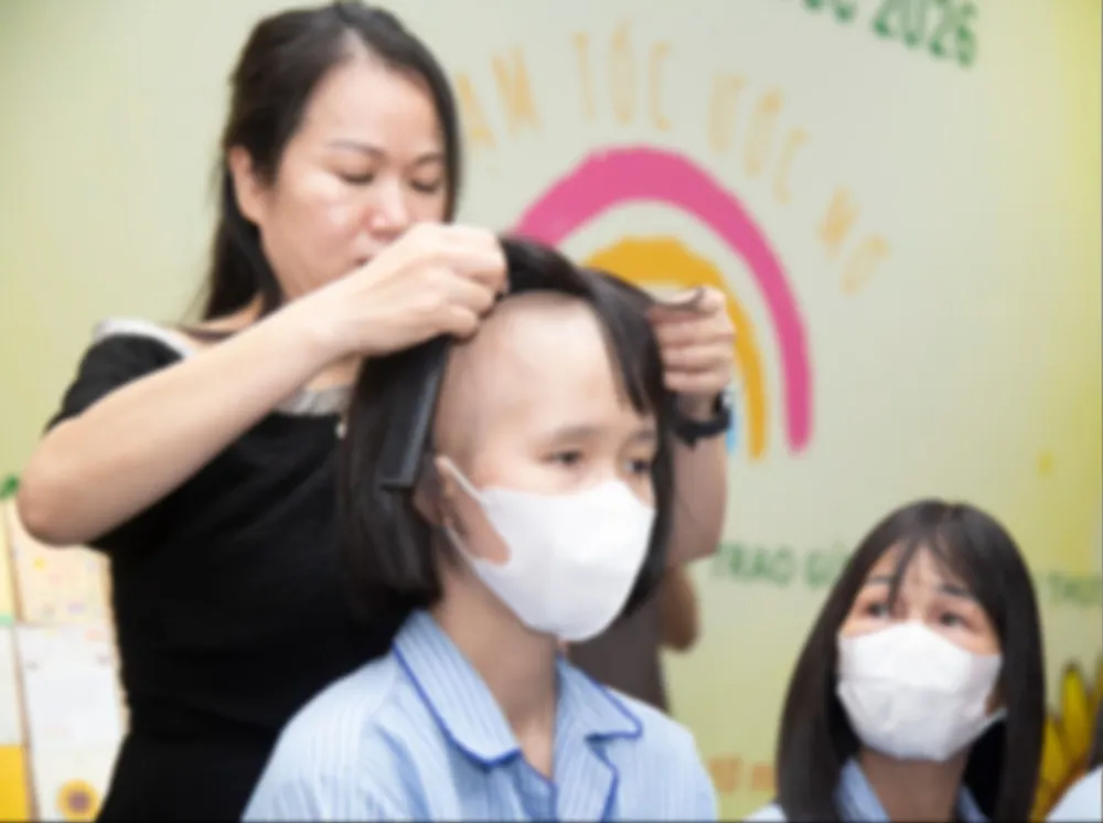 Một bệnh nhân ung thư vui mừng đón nhận mái tóc giả từ chương trình “Trạm tóc ước mơ”. Ảnh: THANH HẰNG