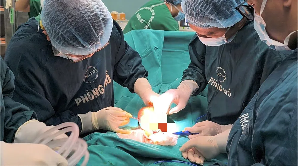 Bác sĩ phẫu thuật cắt vòng kim loại giải phóng vùng bị chèn ép. Ảnh: ĐẶNG THANH