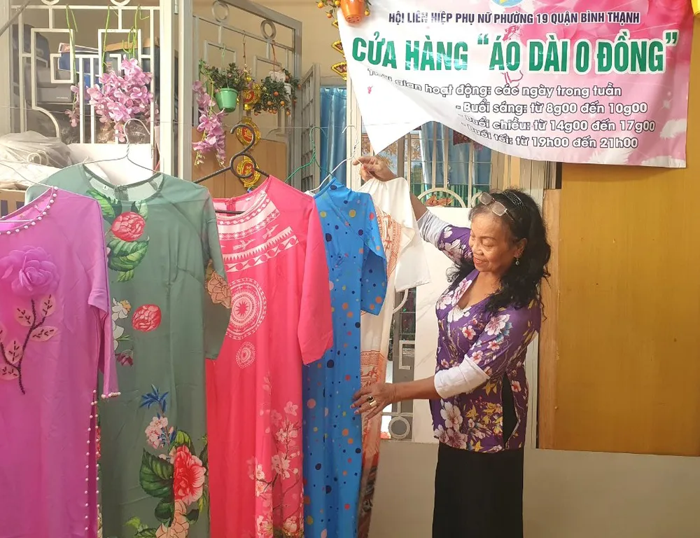 Bà Sầm Kim Tương bên những chiếc áo dài chuẩn bị để tặng phụ nữ khó khăn. Ảnh: HỒNG HẢI