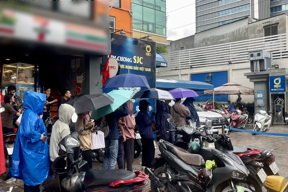 Người dân đội mưa mua vàng tại Công ty Vàng bạc Đá quý SJC (418-420 Nguyễn Thị Minh Khai, phường Bàn Cờ, TPHCM) vào sáng 3-10. Ảnh: HOÀNG HÙNG