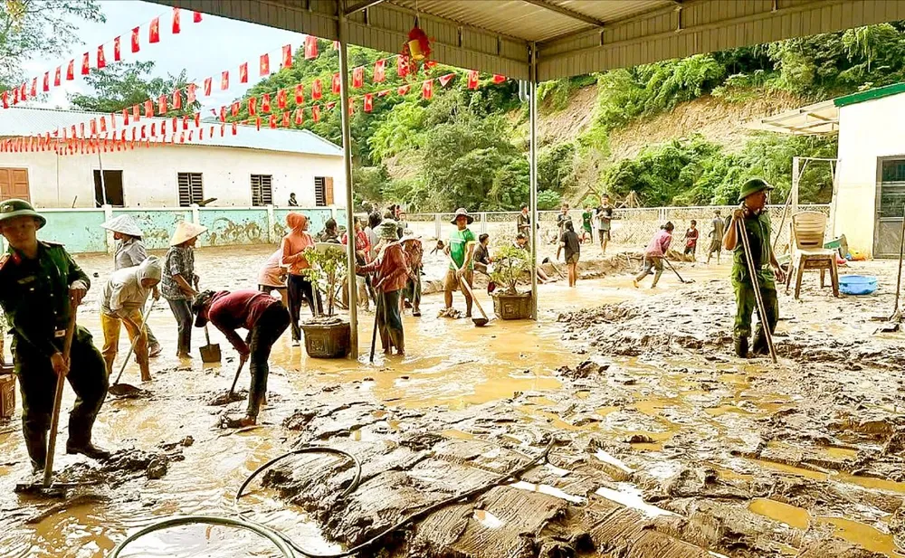 Dọn dẹp bùn sau mưa lũ tại Trường Mầm non Mường Típ (xã Mường Típ, tỉnh Nghệ An)