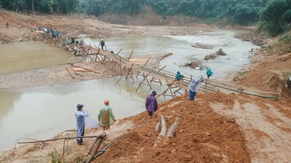 Tuy thời tiết mưa gió nhưng ai cũng hăng hái làm việc để con em đến trường được an toàn.jpg