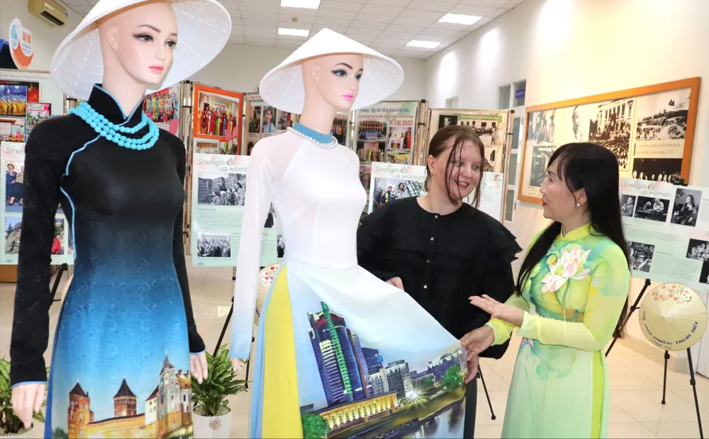 Bà Trịnh Thị Thanh giới thiệu về chiếc áo dài truyền thống Việt Nam đến bà Palina Karpava. Ảnh: THÁI PHƯƠNG
