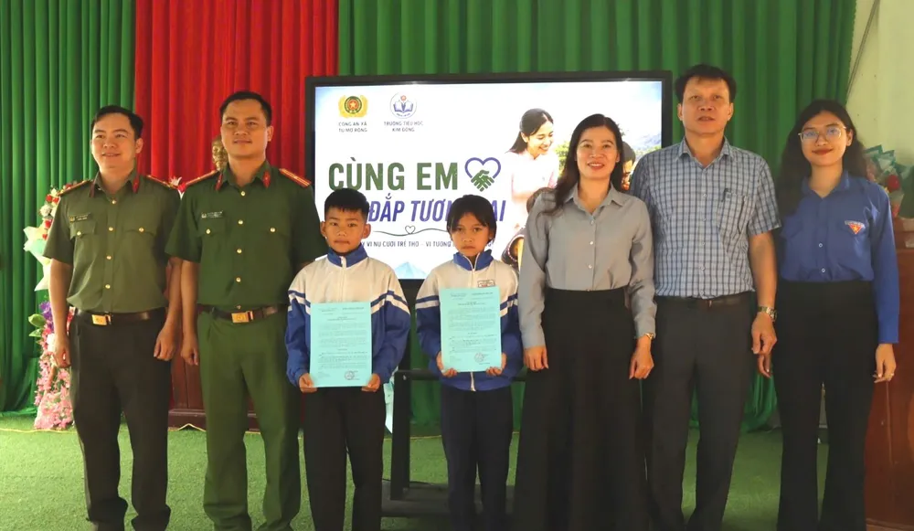 Trao bản thực hiện chương trình Bạn đồng hành áo xanh để giúp đỡ cho học sinh có hoàn cảnh khó khăn. Ảnh: HỮU PHÚC