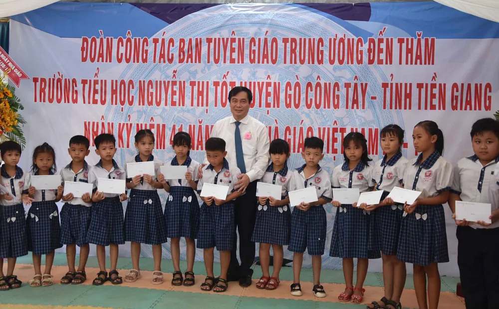 Đồng chí Phan Xuân Thủy trao quà cho các em học sinh khó khăn, học giỏi