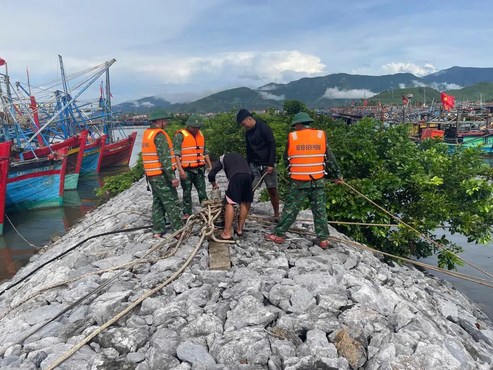 Bộ đội biên phòng đồn Roòn giúp dân chằng néo thuyền trong âu tàu Roòn