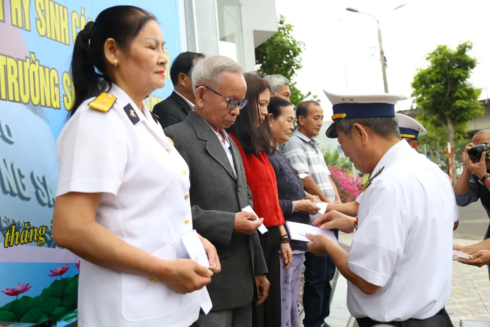 Ban tổ chức trao quà cho gia đình các liệt sĩ. Ảnh: PHẠM NGA