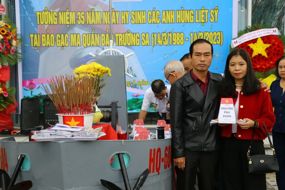 Người thân chụp ảnh kỷ niệm trước bài vị của liệt sĩ Nguyễn Phú Đoàn. Ảnh: PHẠM NGA