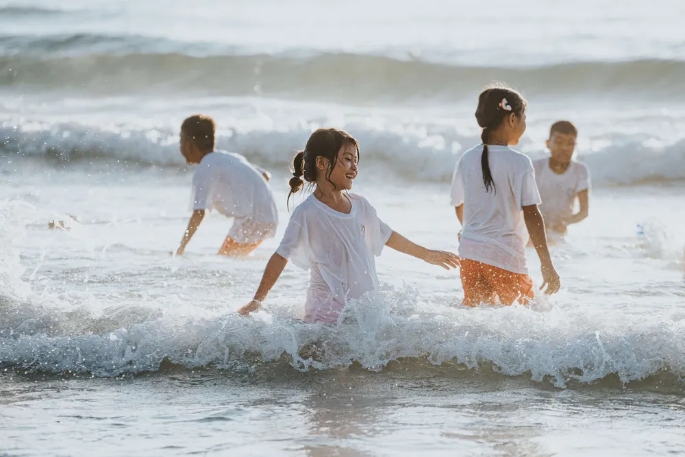 Đặc biệt, với nhiều em, đây là chuyến đi đầu tiên trong đời, được khám phá thế giới bên ngoài rộng lớn phía sau màu xanh của núi rừng. Khác với ngày thường, thay vì phải vào rừng hái rau, kiếm củi thì ở đây, các em được tắm biển, vui chơi và cười nói một cách hồn nhiên. Ảnh: TÙNG QUÂN