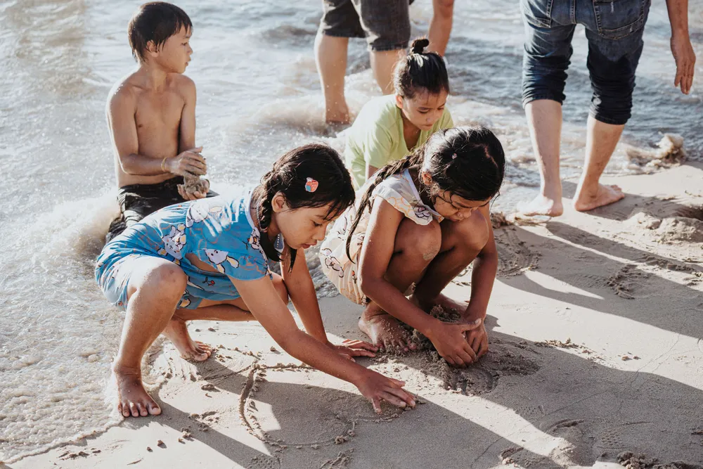 Những vị khách nhí hớn hở chơi đùa trên biển, vẽ hình trên cát, xây lâu đài cát... Ảnh: TÙNG QUÂN