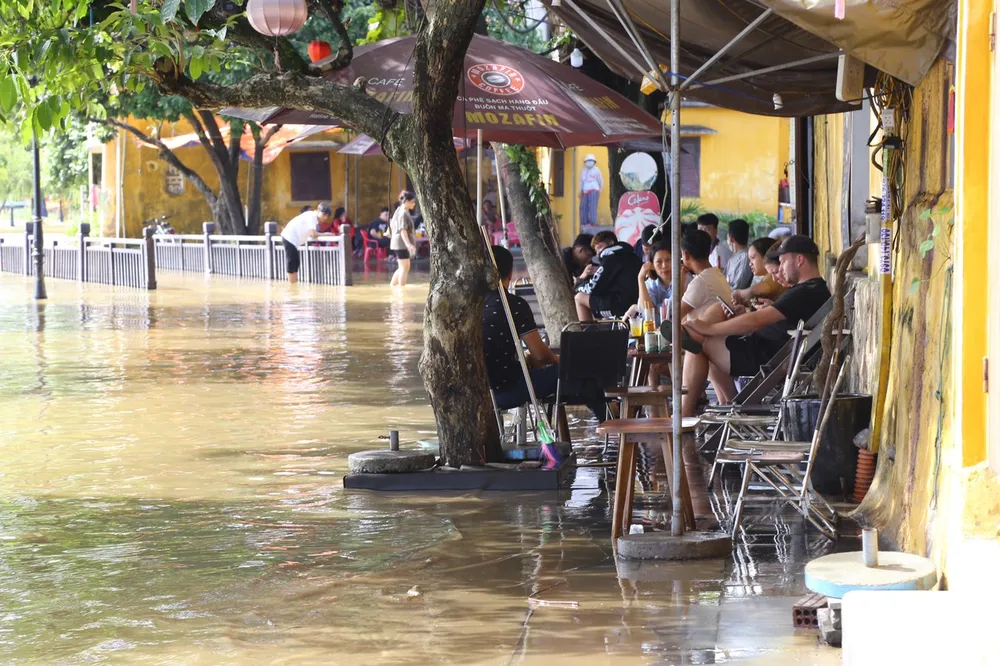 Những quán cafe dọc đường Nguyễn Thái Học, Bạch Đằng,... đông đúc du khách ngồi ngắm khung cảnh nên thơ của Phố cổ Hội An những ngày mưa lũ