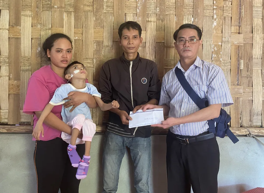 Nhà báo Nguyễn Hùng (Trưởng đại diện Báo SGGP tại miền Trung) trao 20 triệu đồng tiền hỗ trợ gia đình cháu Alăng Thị Hồng Ánh