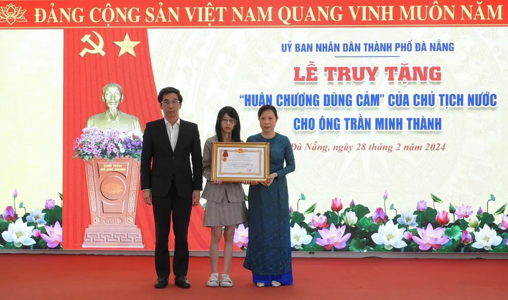 Thừa uỷ quyền của Chủ tịch nước, Phó Chủ tịch TP Đà Nẵng Trần Chí Cường truy tặng Huân chương Dũng cảm cho vợ và con gái ông Thành. Ảnh: DOÃN HÙNG