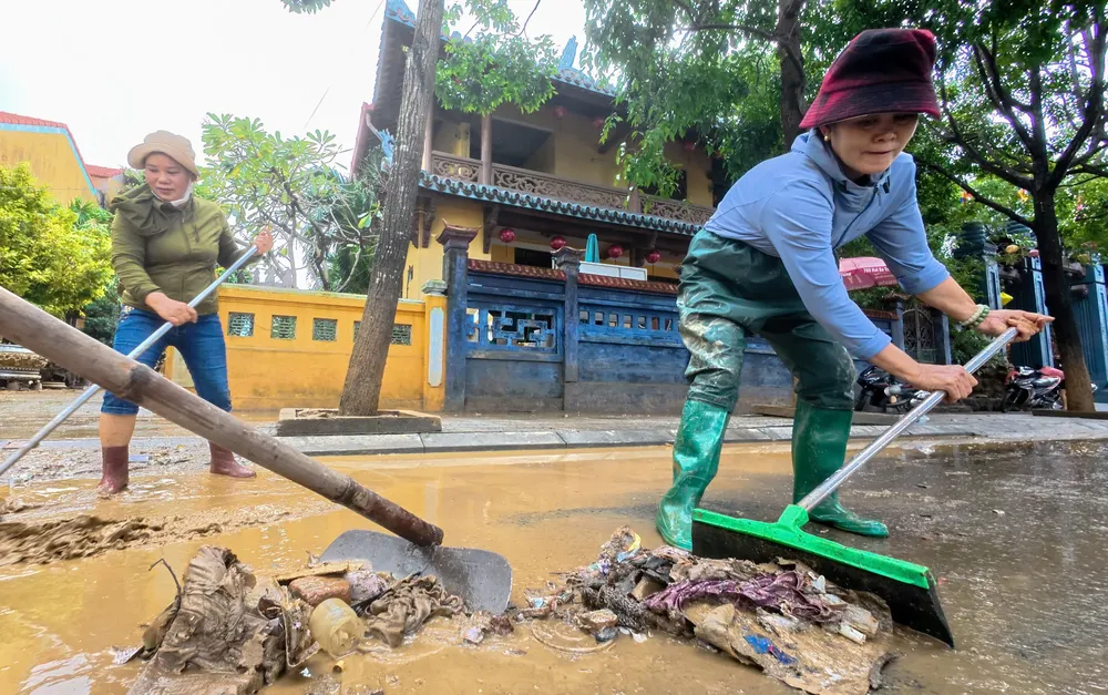 Nước lũ rút, bùn non lộ ra từng lớp dày đặc trên mặt đường