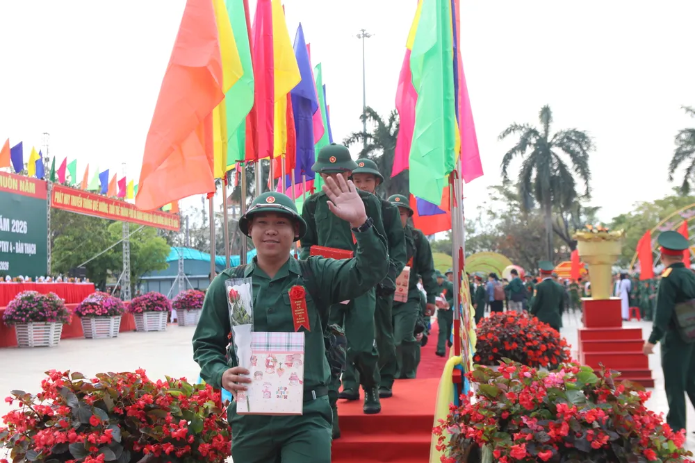 Công dân cười tươi vẫy tay chào người thân sau khi đi qua cầu vinh quang. Ảnh: NGUYỄN CƯỜNG