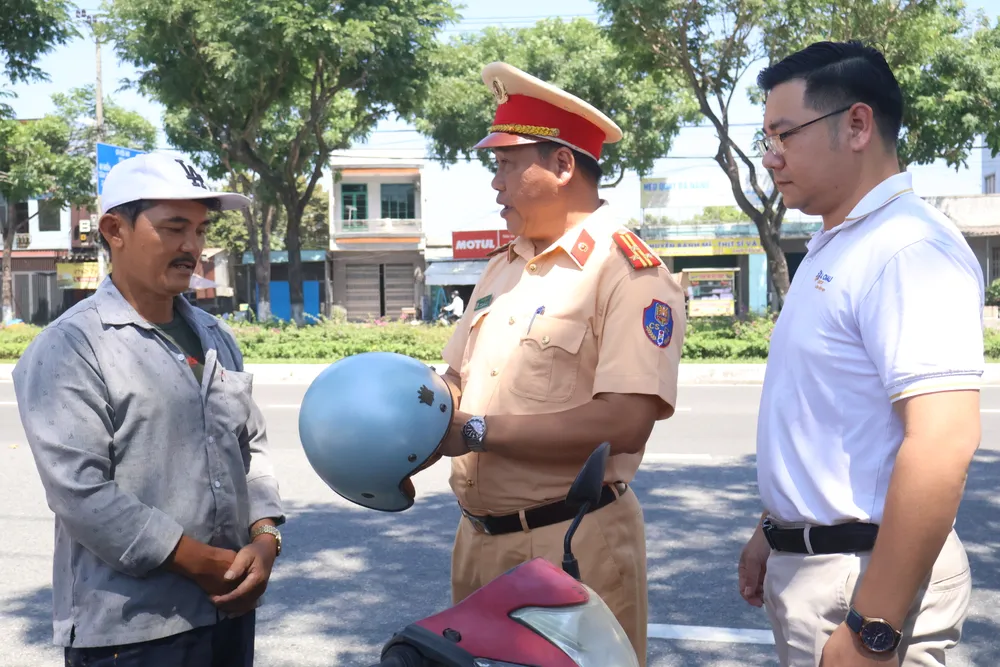 Thượng tá Phạm Hồng Hải, Phó Trưởng phòng CSGT tuyên truyền, tặng mũ bảo hiểm đạt chuẩn cho người dân