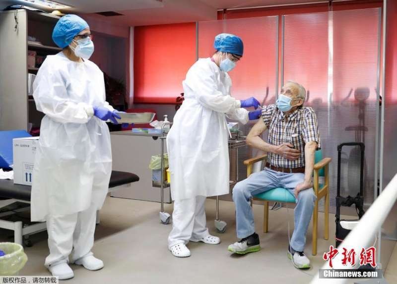 西班牙醫護人員正在為一名72歲的老人進行新冠疫苗接種工作。