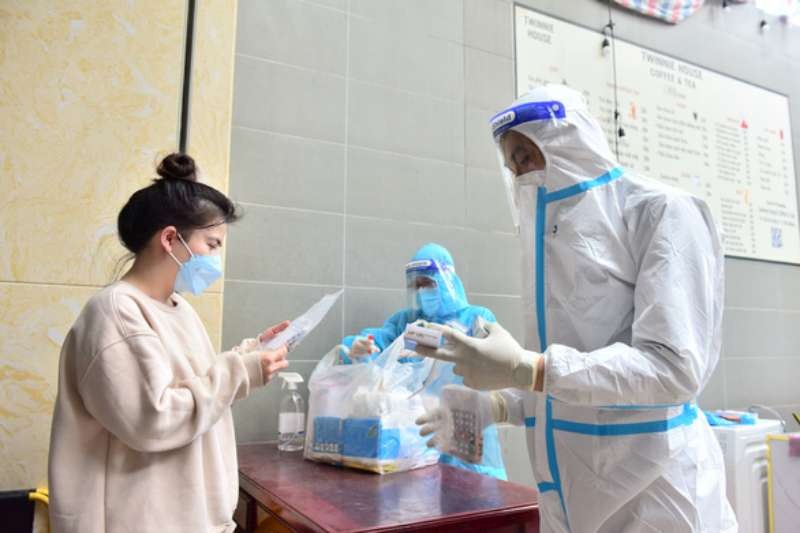 醫護人員在指引居家治療確診者使用藥品。