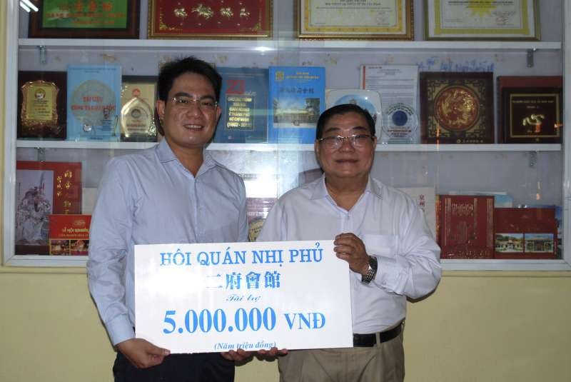 二府會館理事長彭偉強(右)把贈款交給本報編委文忠孝。