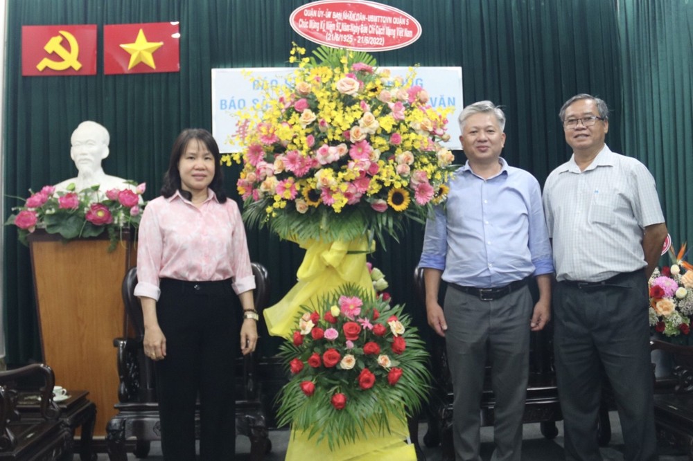 本報編委黎曰孟雄接受第五郡代表團 贈送的鮮花。