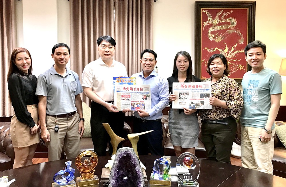 本報編委文忠孝(左四)向簡智明董事長 (左三)贈送日報和春刊。