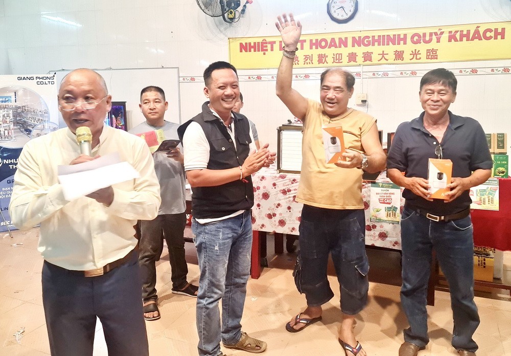 理事長鄭成龍（左）主持慶祝關平太子寶誕聚會上的幸運抽獎活動。