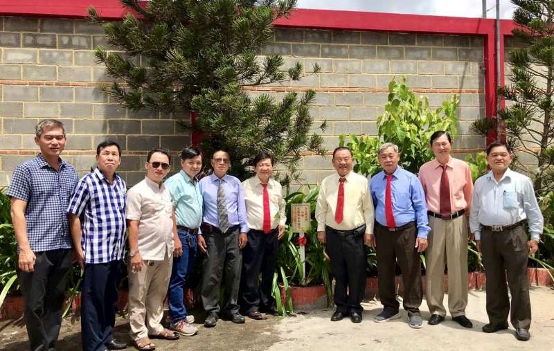 崇正慈善會館理事在觀音閣栽種松樹。