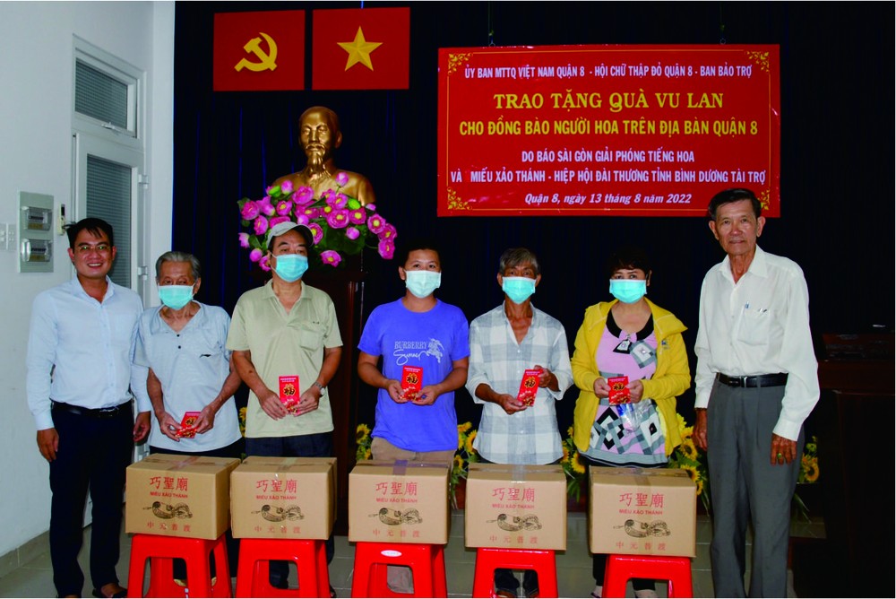 本報編委文忠孝(左一)與第八郡郡紅十字輔助會副會長陳健安(右一)向華人貧困戶轉送盂蘭節禮物。