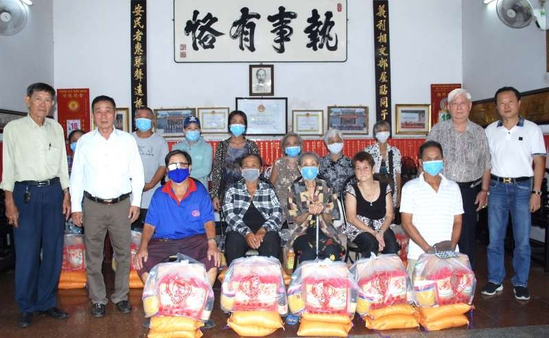 義安會館理事長陳裕、副理事長鄭學才向貧困者派發盂蘭賑濟品。