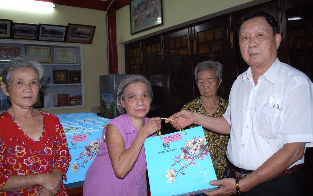 二府會館副理事長謝忠成(右一)向鄉親贈送月餅。