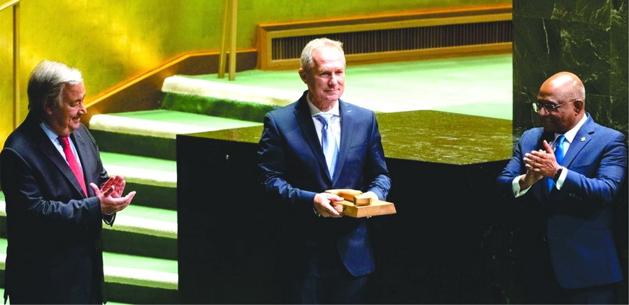 聯大第七十七屆會議當選主席克勒希（中）接過議事槌，古特雷斯與沙希德為其鼓掌。