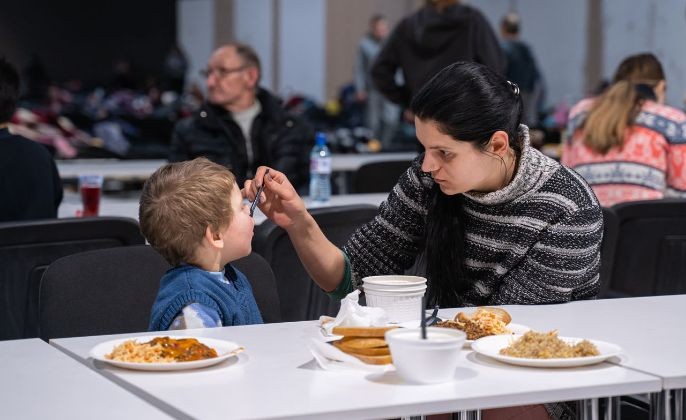 圖為在波蘭華沙，一名烏克蘭婦女在餵自己的孩子吃飯。（圖：新華社）