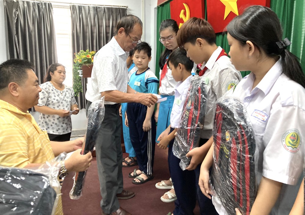 各热心人士向清贫学生颁发助学金与礼物。