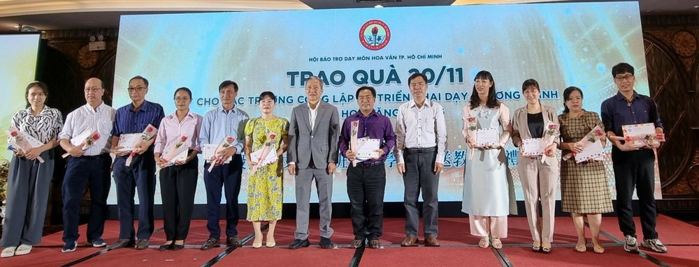 市民族处副主任曾福禄(右五)与陈家义先生(右七)向各校代表赠送鲜花和礼物祝贺。