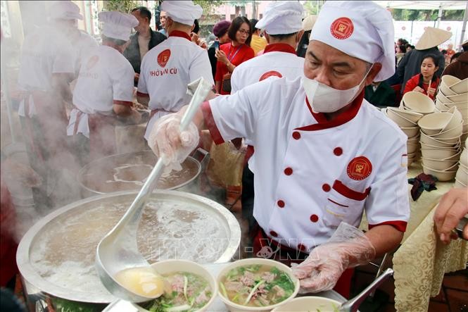 各位厨师烹制牛肉粉为民众服务。