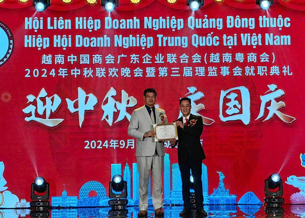 中国驻本市总领馆总领事魏华（左）向应届会长曹高峰授牌。