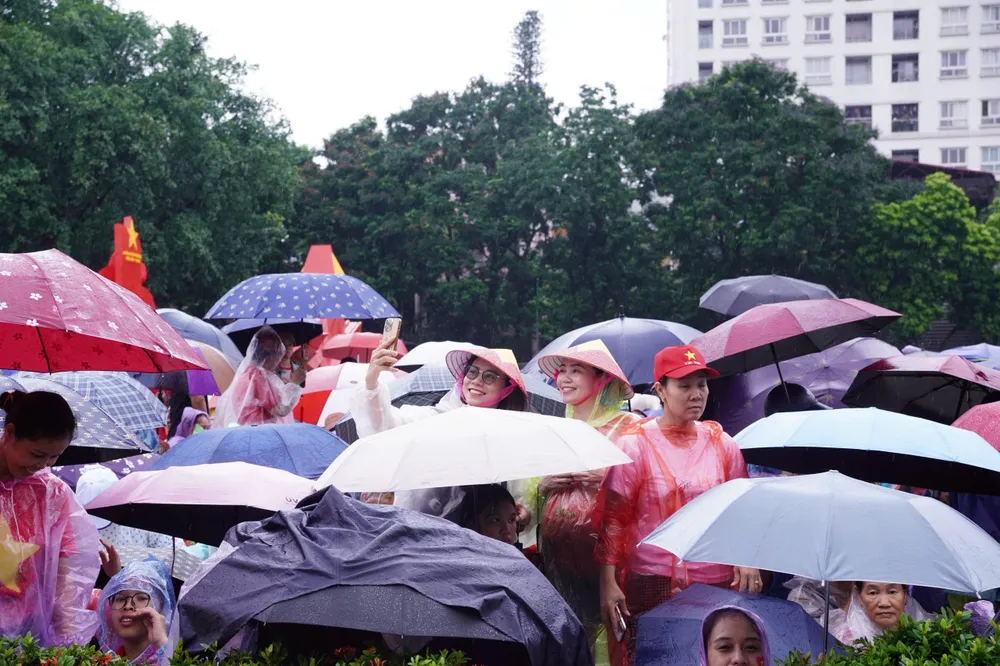 Người dân đứng dưới mưa đợi đến giờ sơ duyệt