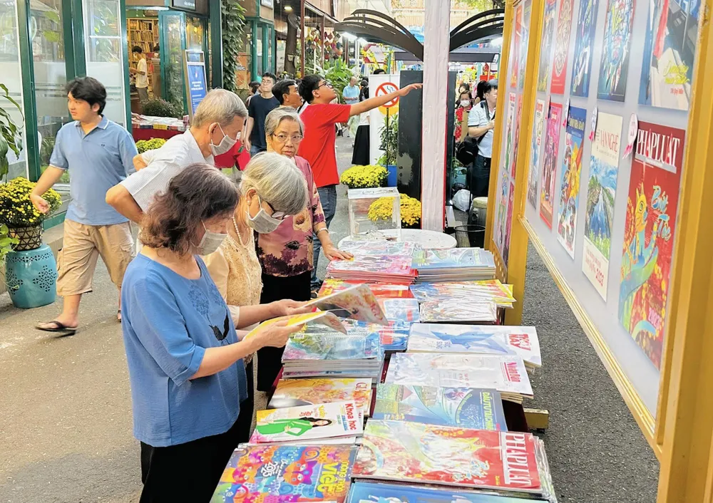 Đọc báo xuân tại Triển lãm báo xuân Đường sách TPHCM. Ảnh: TIỂU TÂN Đọc báo xuân tại Triển lãm báo xuân Đường sách TPHCM. Ảnh: TIỂU TÂN