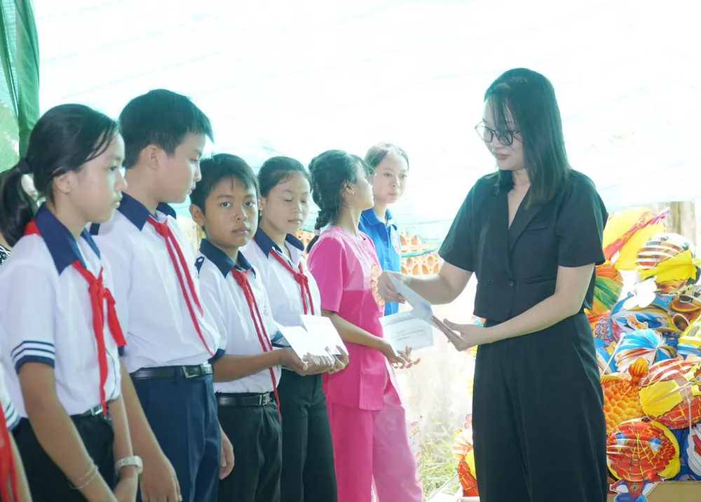 Bà Nguyễn Thị Trang, đại diện Truyền thông Amway Việt Nam, trao học bổng cho học sinh khó khăn, hiếu học. Ảnh: VIỆT NGA